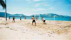 Travellers playing tennis on beach at Rio de Janeiro, Brazil