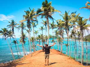 Person with their arms up on Mirissa beach, Sri Lanka