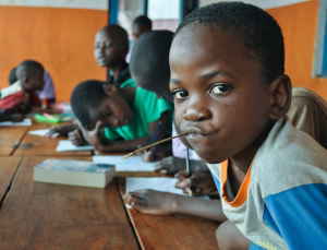 Schoolchildren in a classroom study books and draw
