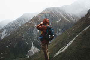 A traveller standing on a mountain taking a photo