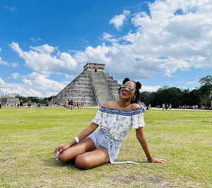Traveller sitting laughing in front of chichen itza