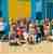 Group of people in swimwear in front of colourful beach huts in Melbourne