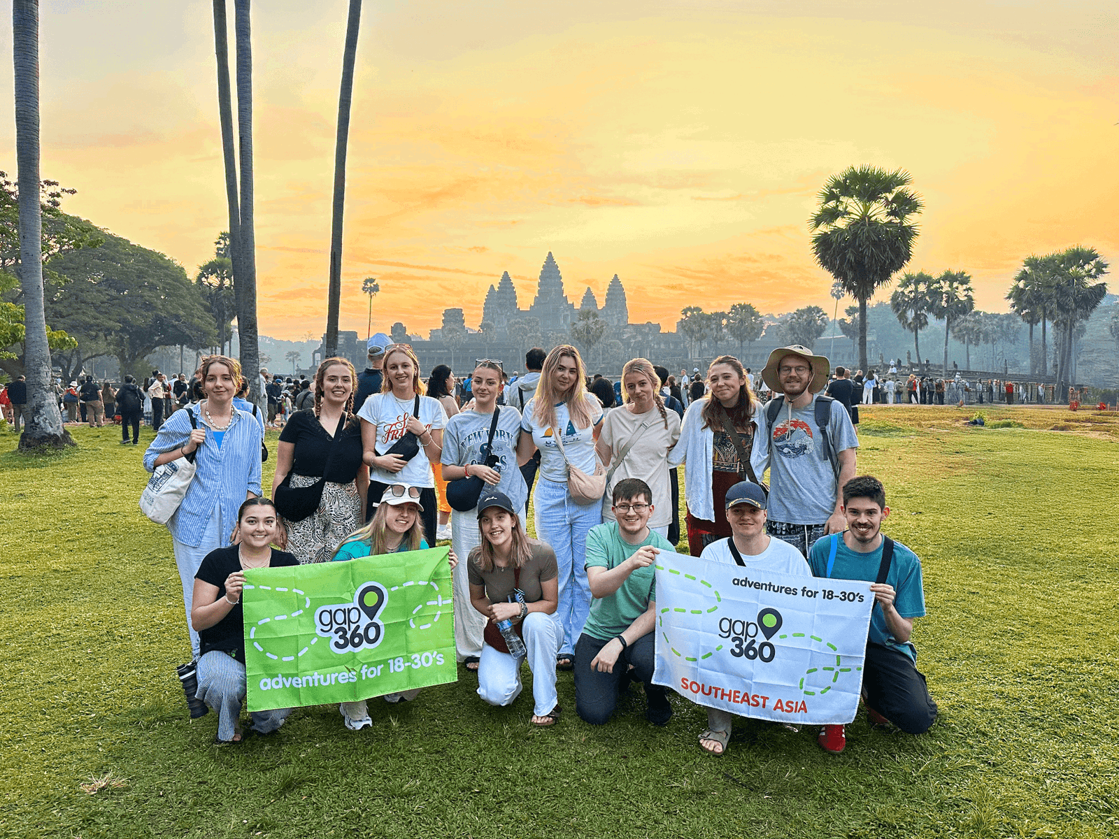 Group Travellers holding flag at Cambodia Angkor Wat at sunrise