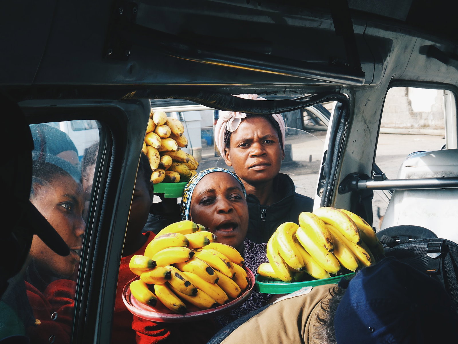 Street vendors trying to sell bananas to people in a vehicle in Tanzania