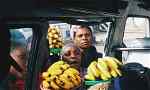 Street vendors trying to sell bananas to people in a vehicle in Tanzania