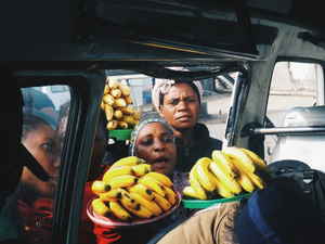 Street vendors trying to sell bananas to people in a vehicle in Tanzania