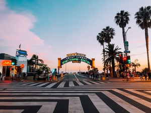 A street crossing and archway with the words 'Santa Monica' at sunset