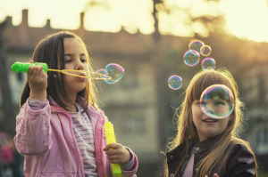 Two children blowing bubbles