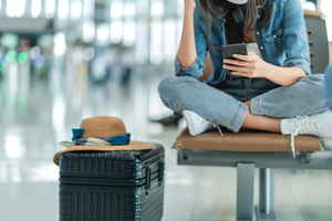 traveller looking at phone in the airport