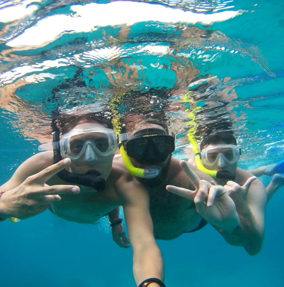 Three travellers underwater in scuba gear