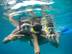 Three travellers underwater in scuba gear