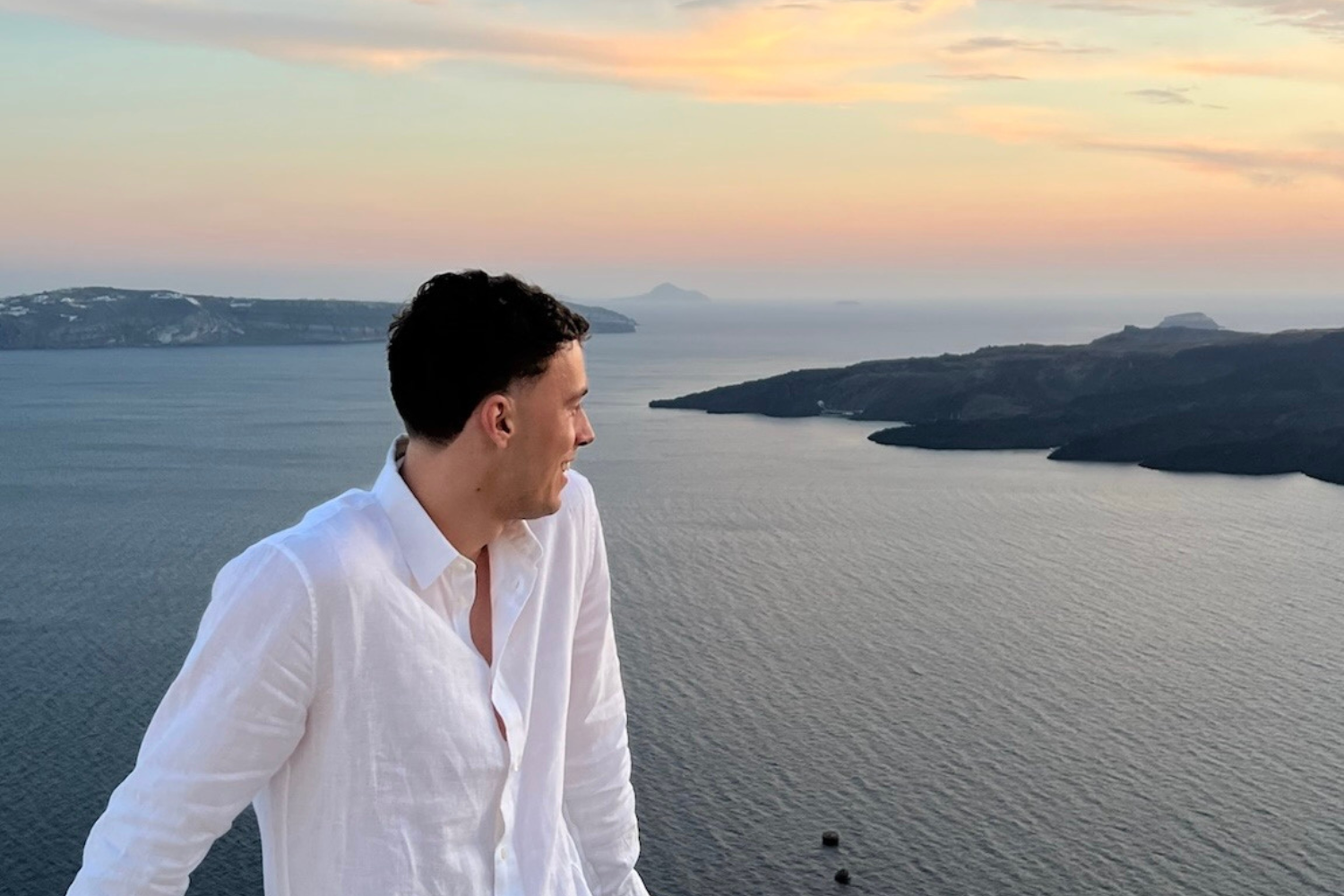 Traveller looking across Greek islands at sunset 
