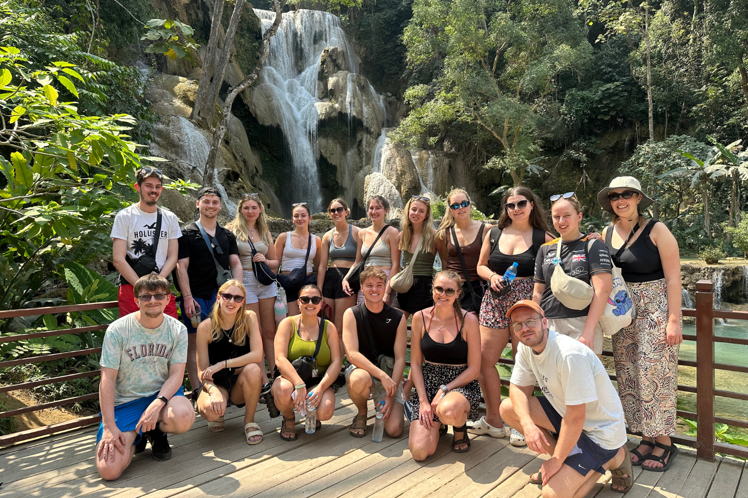 Group on a trip to Laos, standing in front of Kuang Si Falls 