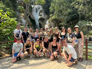 Group travellers at waterfall in Laos