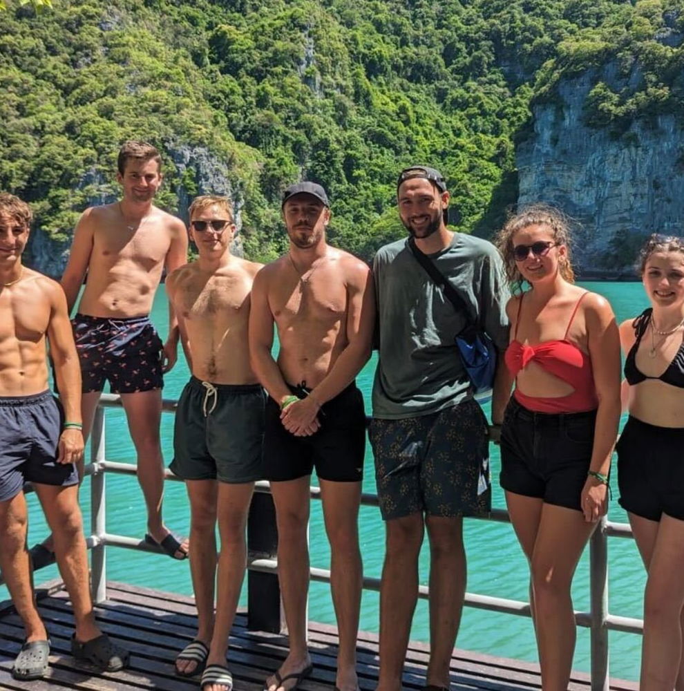 Group of travellers smiling at sunny viewpoint in Thailand