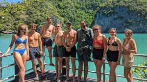 Group of travellers smiling at sunny viewpoint in Thailand