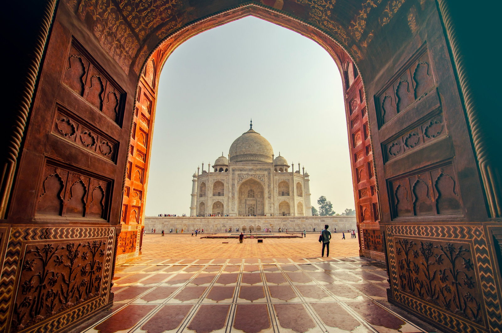 Sunny Taj Mahal through an old large doorway
