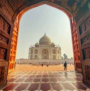 Sunny Taj Mahal through an old large doorway