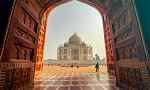 Sunny Taj Mahal through an old large doorway