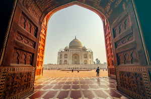 Sunny Taj Mahal through an old large doorway