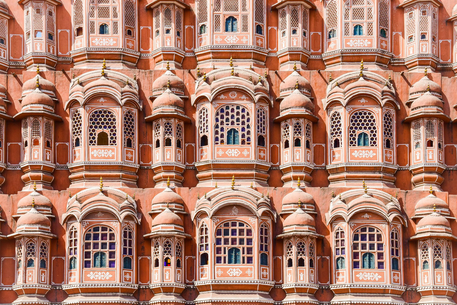 Rows of orange pink domed windows towering on top of each other, Hawal Mahal
