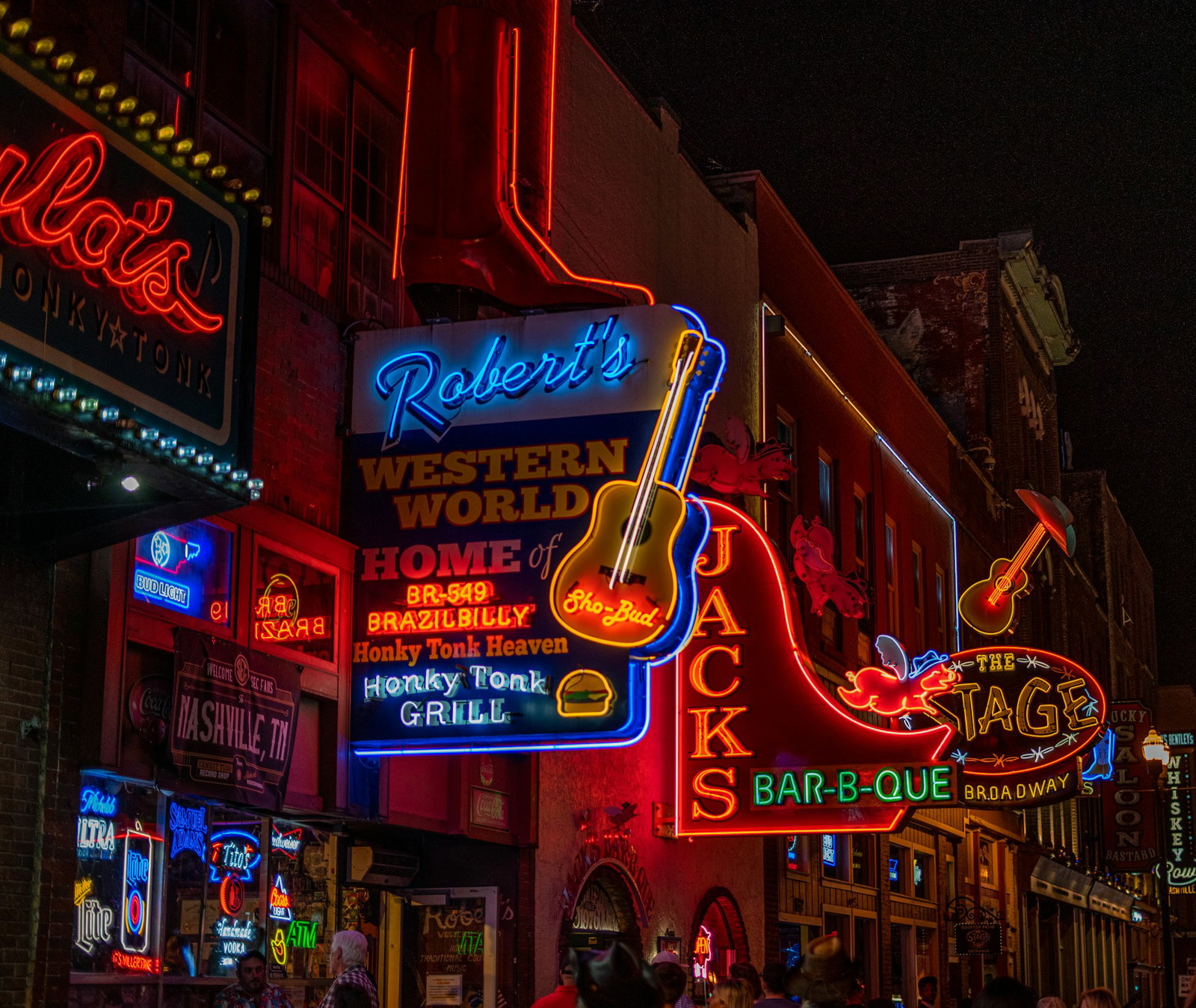 Neon-lit signs featuring guitars and phrases like 