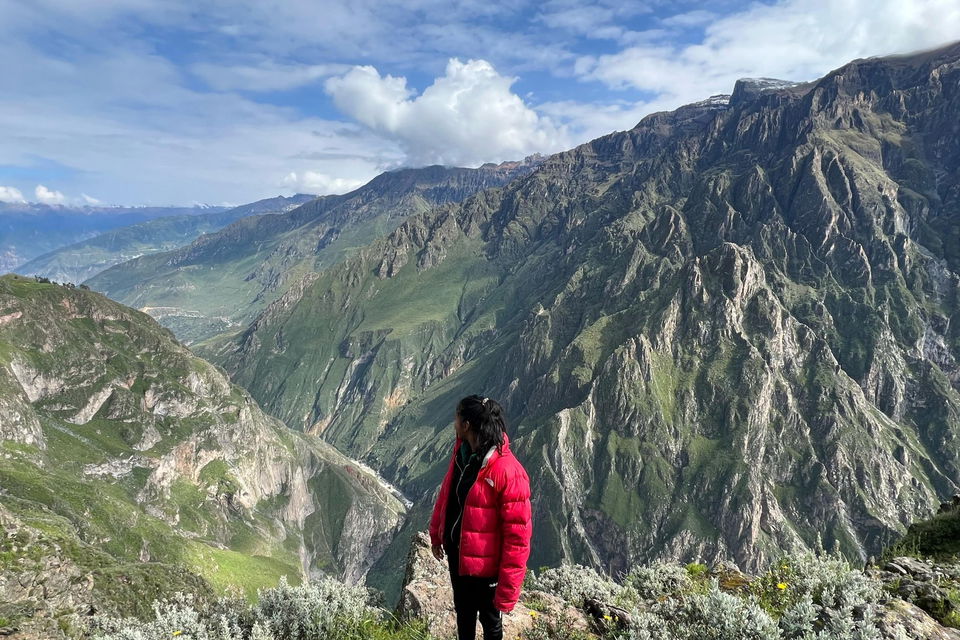 Traveller on a group trip in South America hiking Colca Canyon in Peru, overlooking views of mountains