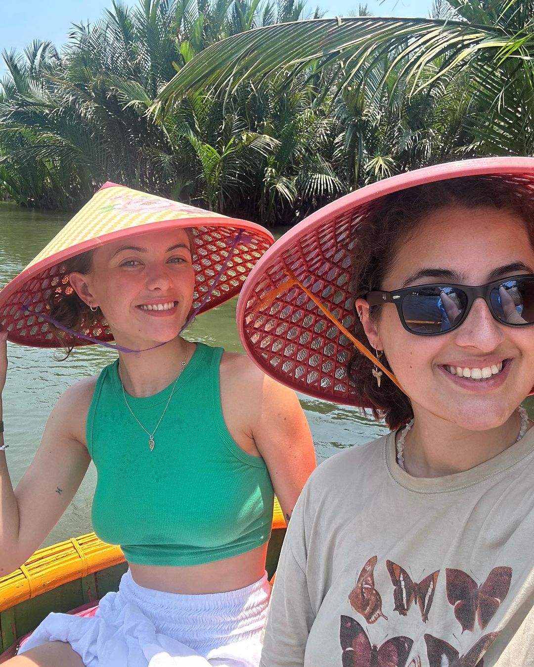 Group travellers on boats in hoi an with vietnamese hats 