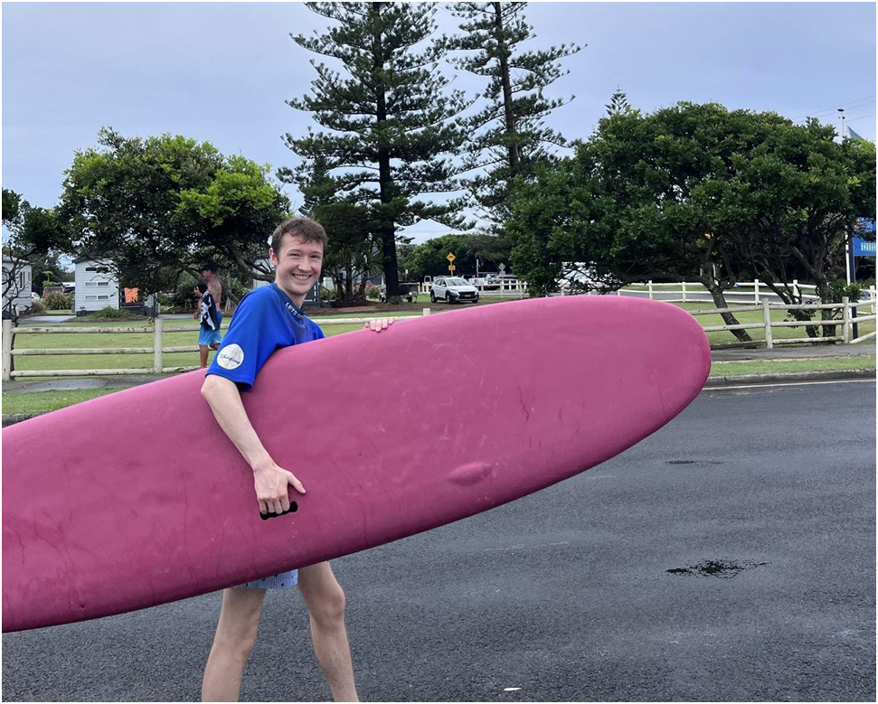 Traveller walking with surf board in Australia