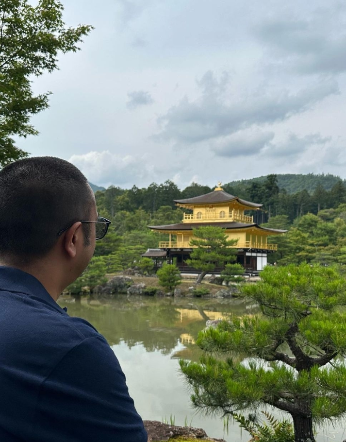 Group travellers looking at golden pavilion in kyoto