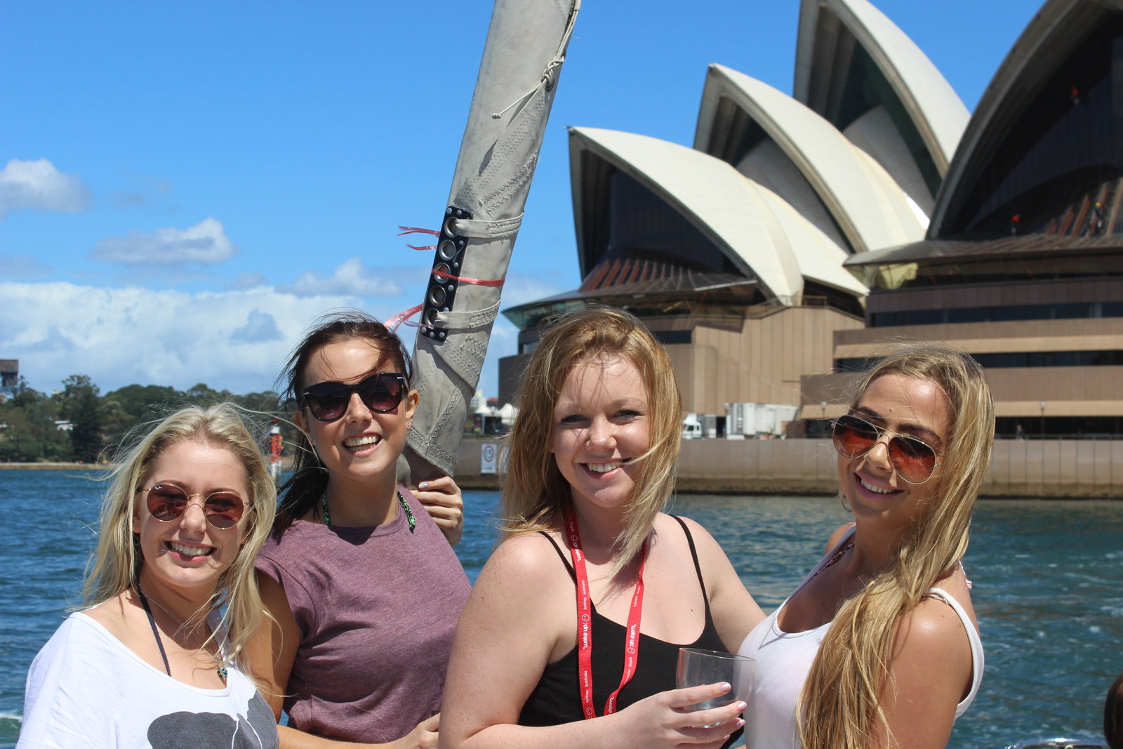 A group of travellers on a boat in front of the Sydney Opera House