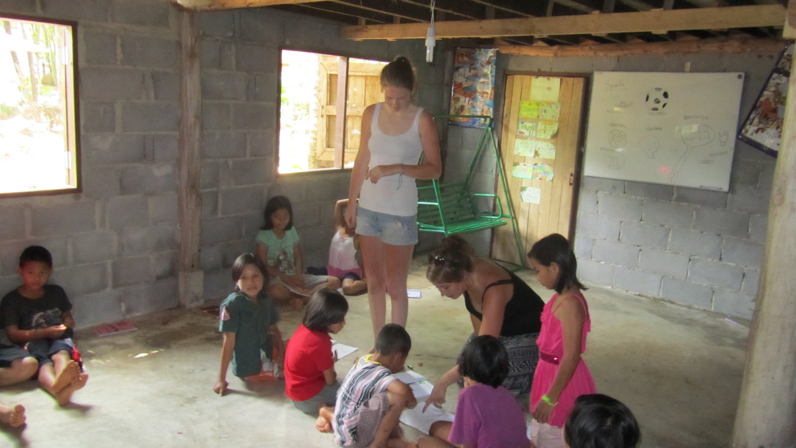 Volunteers in a classroom helping children with schoolwork