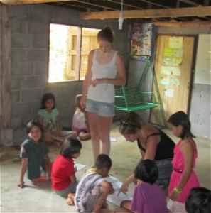 Volunteers in a classroom helping children with schoolwork