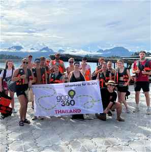 Travellers holding up a Gap 360 Thailand banner