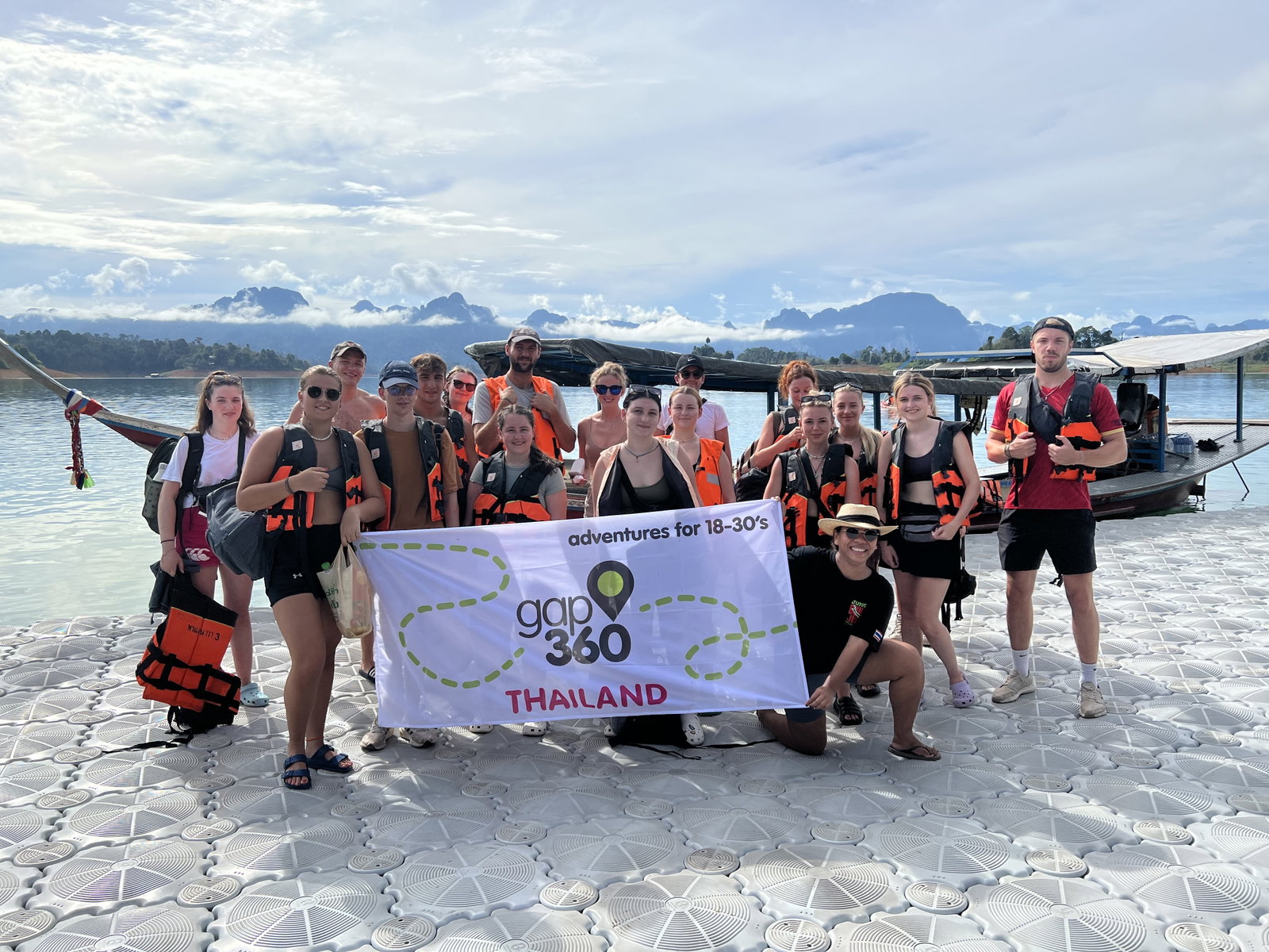 Group holding Gap 360 flag at Koh Sok National Park, Thailand 