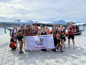 Group holding Gap 360 flag at Koh Sok National Park, Thailand 