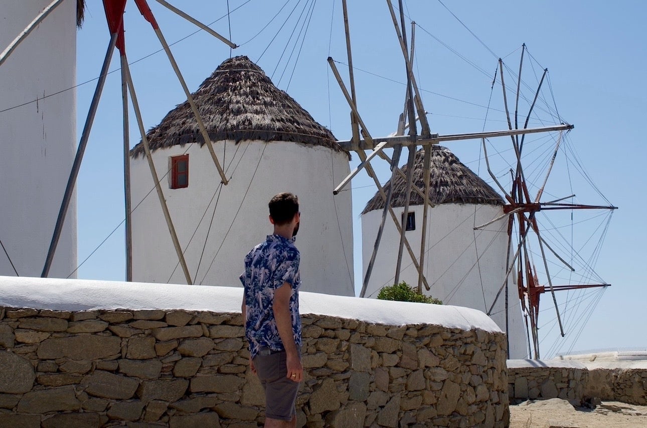Solo traveller looking at greek windmills in Mykonos greece