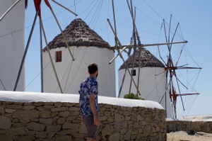 Solo traveller looking at greek windmills in Mykonos greece