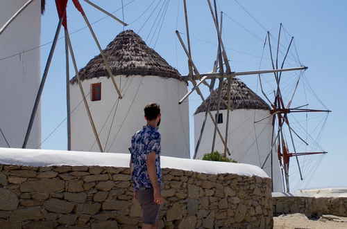 Solo traveller looking at greek windmills in Mykonos greece