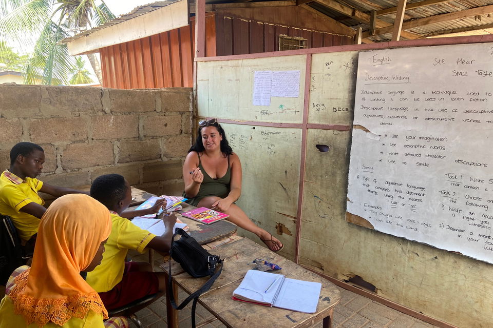 Volunteer teacher with students in classroom in ghana