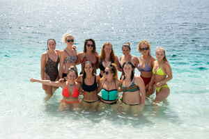 A group of travellers in swimmers in pristine blue water