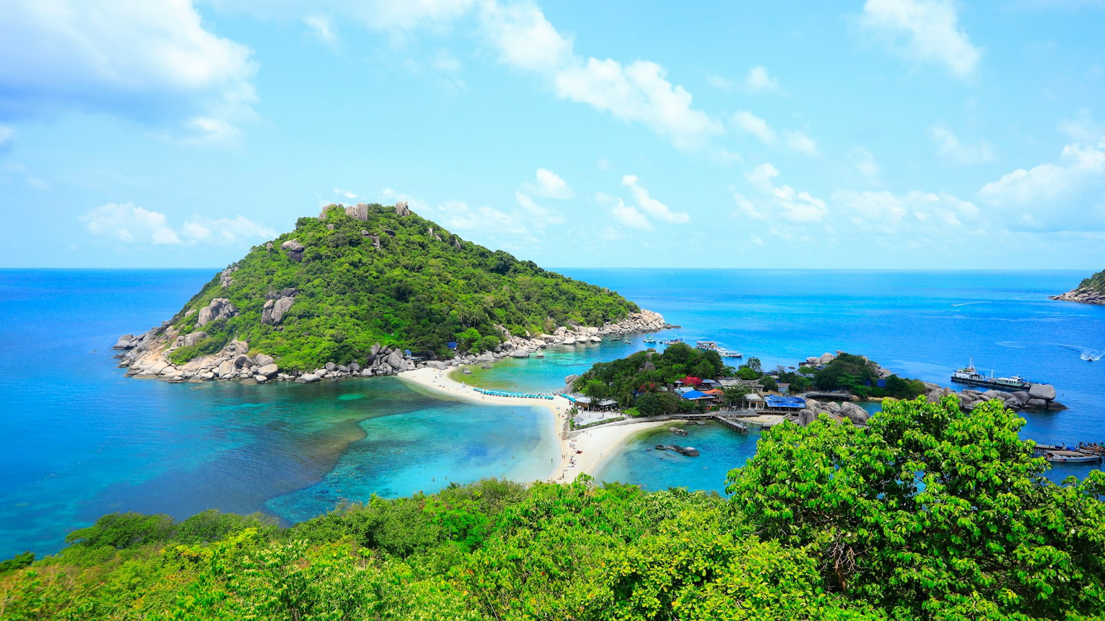 Emerald island hills connected with bright blue waters in between, lowland island in between
