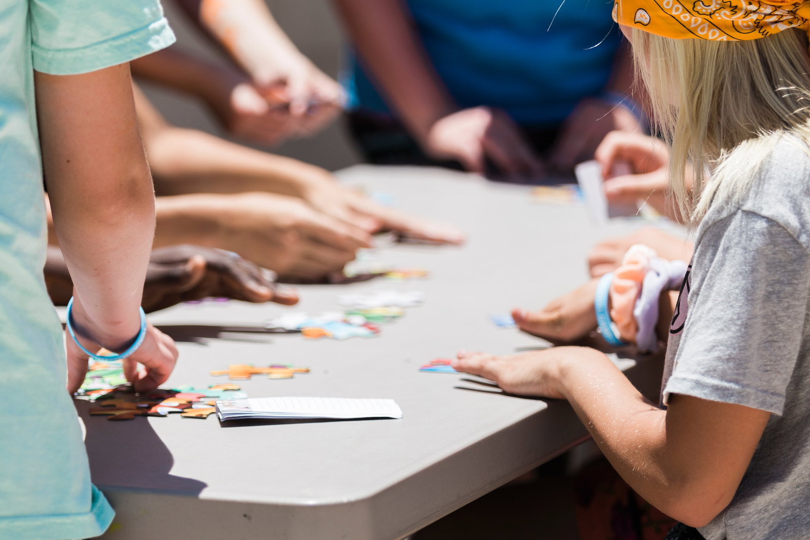 A group of children at a table putting a puzzle together