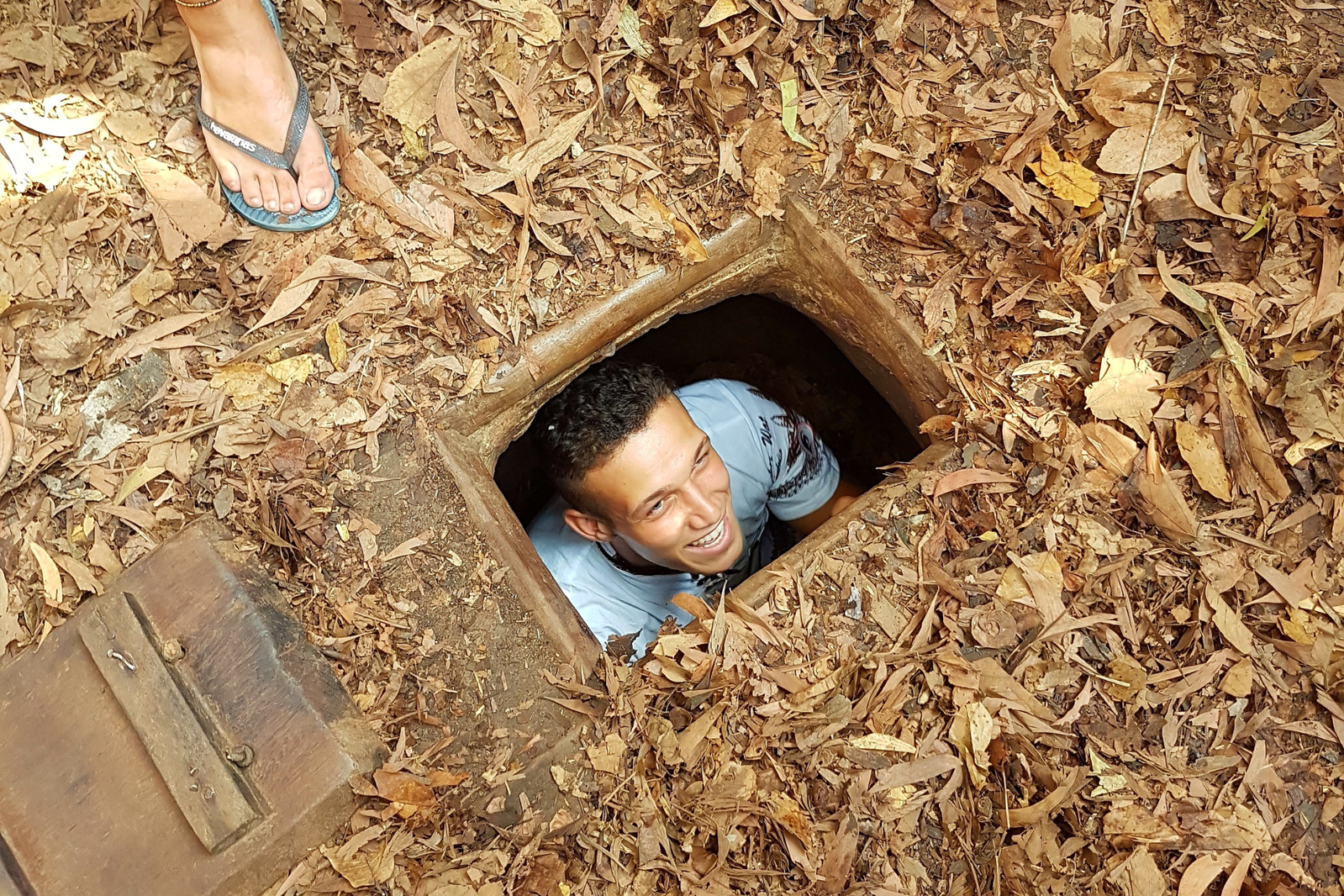 A traveller poking their head out of an entrance to a tunnel