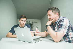 Parent and young adult planning for travels on a laptop