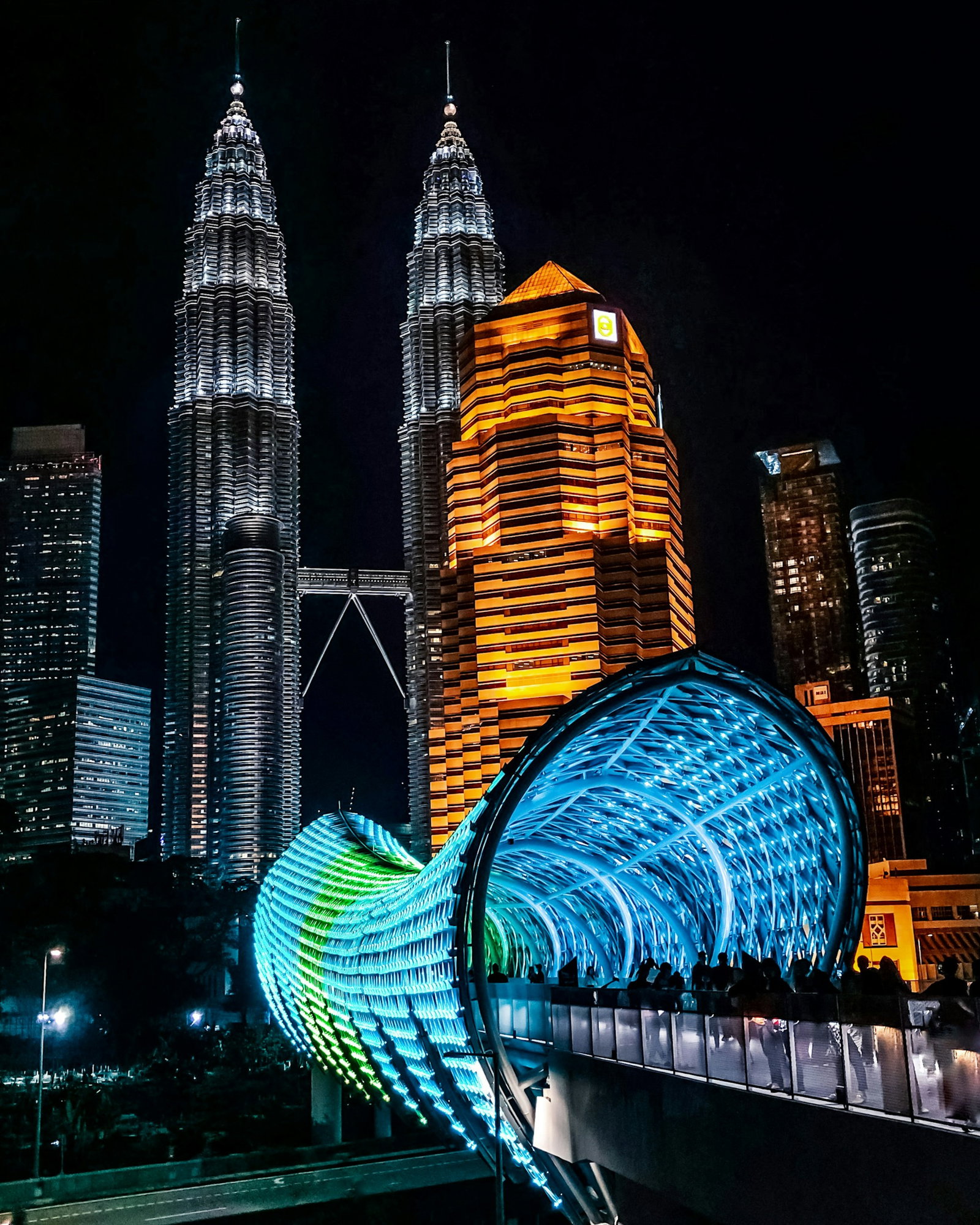 Kuala Lumpur's famous Petronas Towers at night with bridge nearby