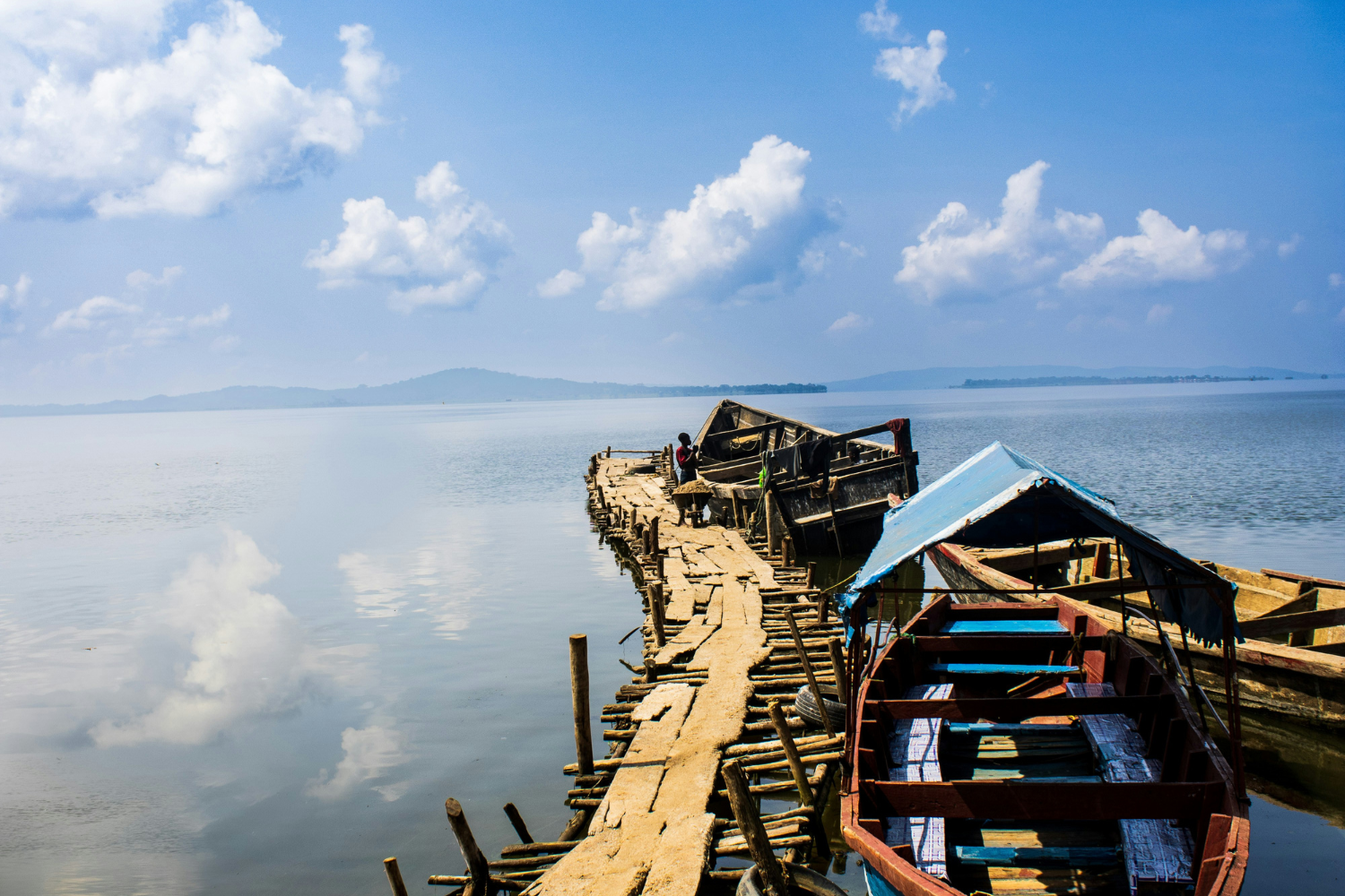 Lake and traditional boat with hills in background in Uganda 