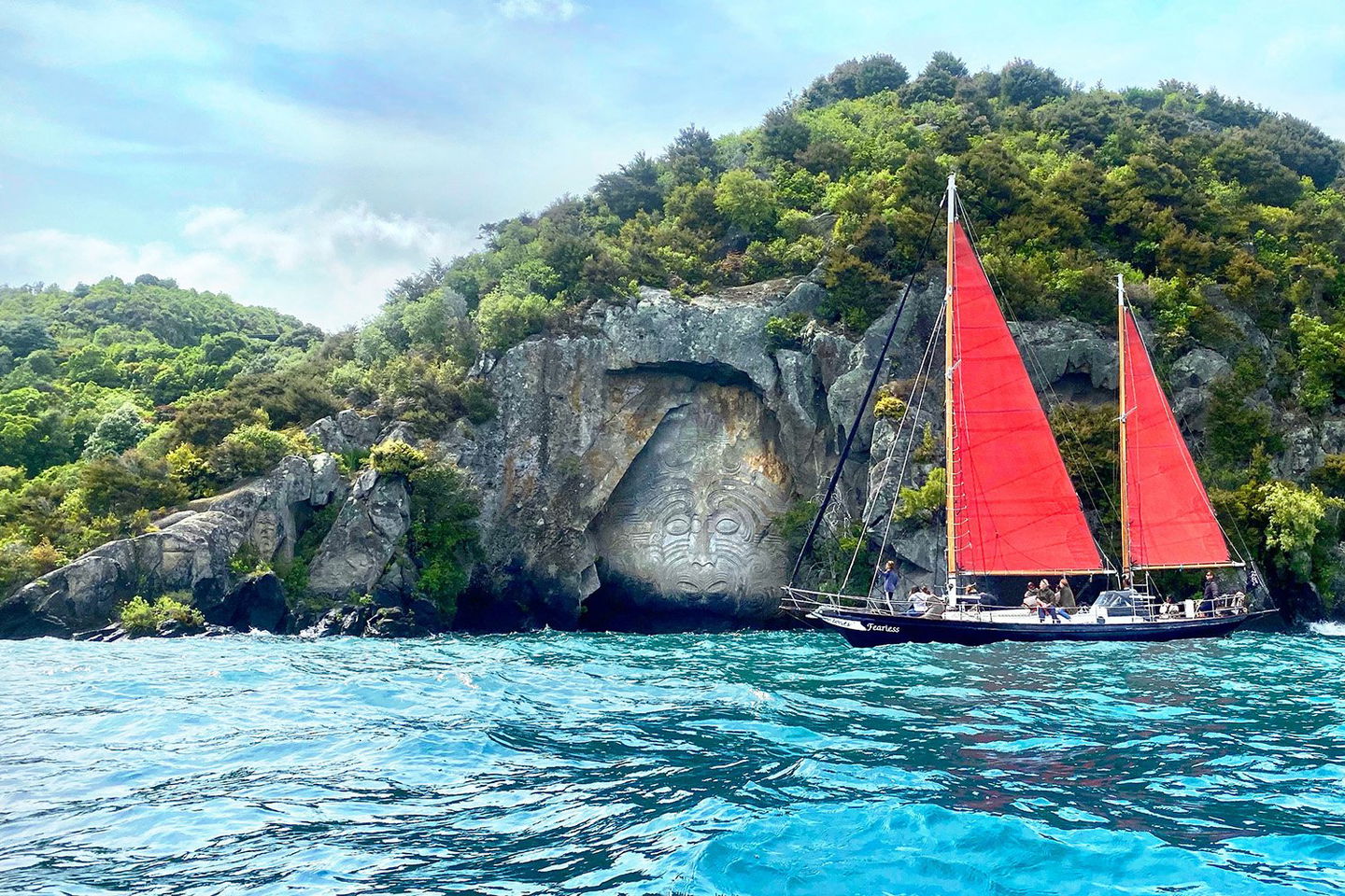Red sail boat on a lake