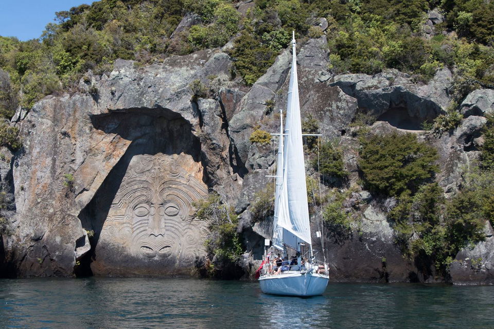 Sailing boat near Maori Rock Carvings in Lake Taupo