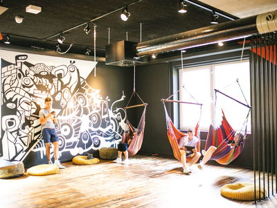 Travellers relaxing in black and white decorated common area in hostel